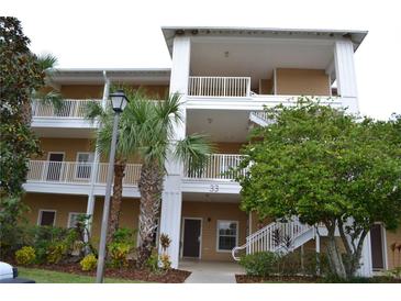 Two-story condo building with palm trees and lush landscaping at 511 Rum Run # 33511, Davenport, FL 33897