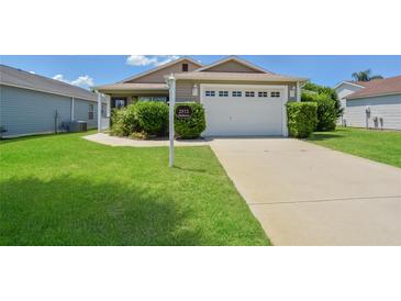 Well-maintained house with a two-car garage and spacious lawn at 2572 Berrington Loop, The Villages, FL 32162