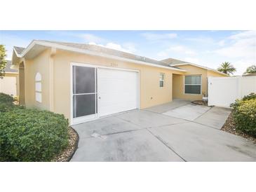 Single-car garage with driveway and landscaping at 2294 Trailwinds Ter, The Villages, FL 32162