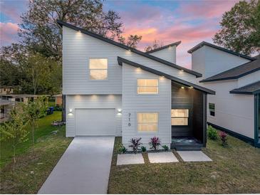 Modern two-story house with white siding and a dark gray accent wall, a landscaped yard and driveway at 716 W 14Th St, Lakeland, FL 33805