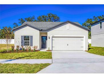 One-story house with gray shutters, attached garage, and well-maintained lawn at 13470 Leaping Water Way, Astatula, FL 34705