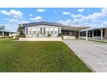 Single-wide manufactured home with carport and spacious lawn at 1610 Reynolds Rd # 159, Lakeland, FL 33801