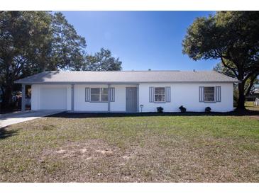 Newly renovated single story home with a white exterior, gray accents, and a neatly landscaped lawn at 3733 Hill St, Lakeland, FL 33812