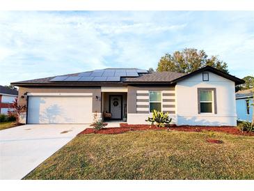 Modern one-story house with solar panels and landscaped yard at 21 Peterlee Ct, Kissimmee, FL 34758