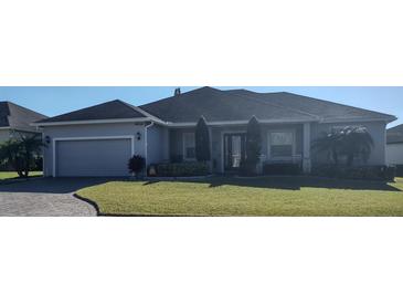 Gray house with a two-car garage and landscaped lawn at 4434 Micanope Crescent Dr, Lakeland, FL 33811