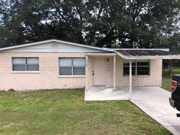 Ranch-style home with a carport and light pink exterior at 1729 Bush Ave, Lakeland, FL 33805