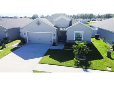 Single-story home with gray exterior, two-car garage, and well-manicured lawn at 6855 Mossy Oak Ln, Lakeland, FL 33810