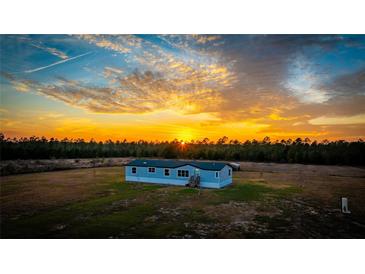 Mobile home on a large lot at sunset at 7435 Postal Colony Rd, Clermont, FL 34714