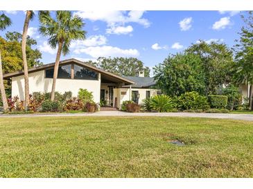 Charming single-story home with lush landscaping and palm trees at 1212 Lake Point Dr, Lakeland, FL 33813