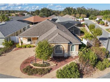 Single-story home with landscaped yard and driveway, located in a residential neighborhood at 1049 Carver Ct, The Villages, FL 32163