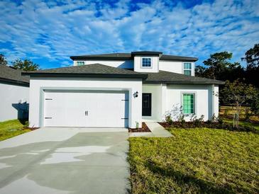 Two-story house with white exterior, gray roof, and a two-car garage at 13466 Leaping Water Way, Astatula, FL 34705