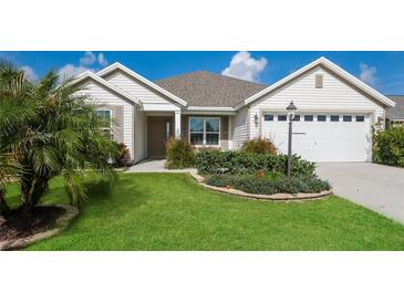 Charming single-story home with a landscaped front yard and two-car garage at 5638 Cedar Waxwing Dr, The Villages, FL 32163