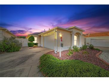 Evening view of charming villa with landscaped yard and attached garage at 17090 Se 76Th Caledonia Ter, The Villages, FL 32162