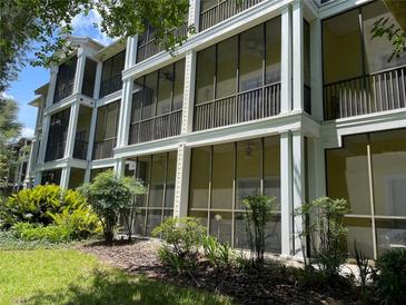 View of a condo building exterior with balconies and lush landscaping at 409 Lucaya Loop # 409, Davenport, FL 33897