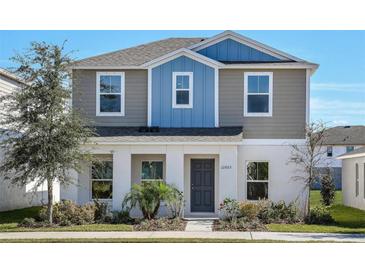 Two-story house with gray and blue siding, landscaping, and a gray front door at 1552 Hummingbird Rd, Winter Haven, FL 33884