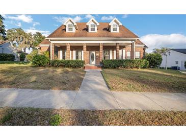 Brick house with a large front porch and manicured lawn at 5325 Charlin Ave, Lakeland, FL 33810