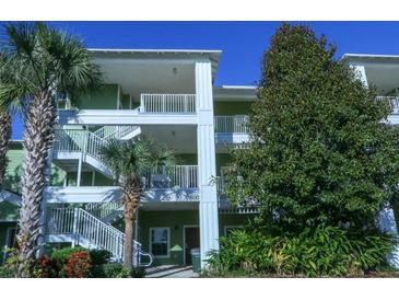 Two-story building exterior with stairs and lush landscaping at 606 Gran Bahama Boulevard # 29-606, Davenport, FL 33897