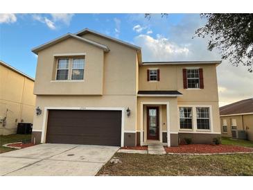 Two-story house with brown garage door and red mulch at 2504 Preserve Ct, Mulberry, FL 33860