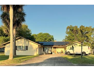 House exterior with solar panels and a large driveway at 748 Merrimac Dr, Port Orange, FL 32127