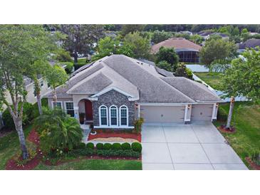 Aerial view of a single-Gathering home with a three-car garage and landscaped yard at 389 Old Alemany Pl, Oviedo, FL 32765