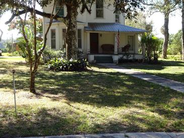 Two-story house exterior with porch and large trees at 207 E 2Nd Ave, Pierson, FL 32180
