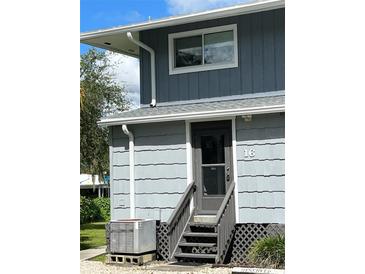 Exterior view of a building with gray siding and stairs at 2329 River Ridge Rd # 160, Deland, FL 32720