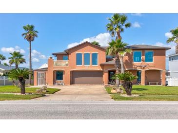 Two-story house with a large garage and palm trees at 3580 Ocean Shore Blvd, Ormond Beach, FL 32176