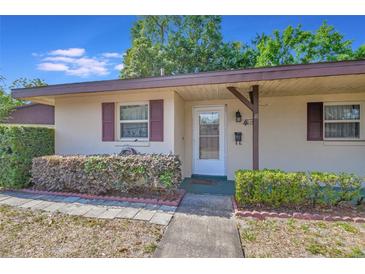 Tan house with maroon shutters and landscaping at 41 Villa Villar Ct # 41, Deland, FL 32724