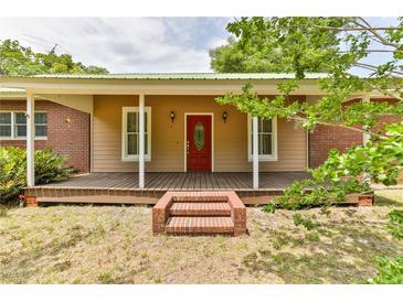 Brick ranch house with a large front porch and red door at 1430 Hazen Rd, Deland, FL 32720