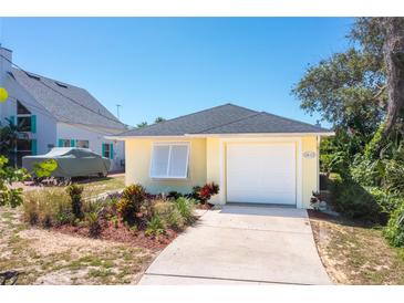 Cute yellow house with a white garage door and well-manicured landscaping at 134 Avalon Dr # A, Ormond Beach, FL 32176