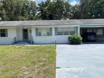 White brick ranch house with carport and mature trees at 2202 Lake Ruby Rd, Deland, FL 32724