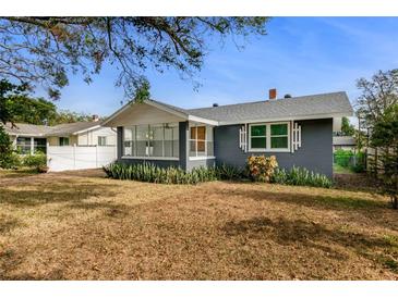 Gray house with a white roof, a screened porch, and a spacious yard at 151 S Ridgewood Ave, Ormond Beach, FL 32174