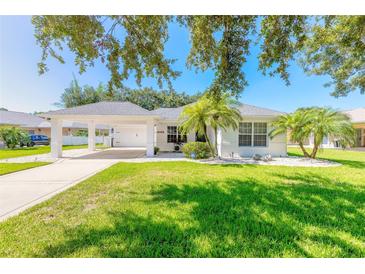 White house with carport, palm trees, and manicured lawn at 4088 Clock Tower Dr, Port Orange, FL 32129
