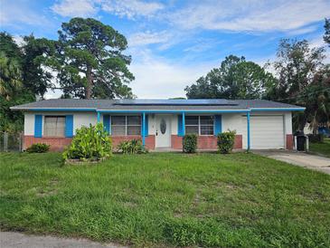 Single story home with solar panels and blue accents at 401 Cherry St, South Daytona, FL 32119
