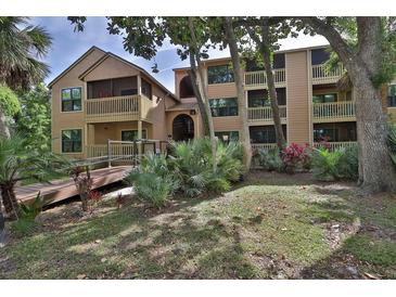 Two-story condo building with balconies and lush landscaping at 1401 S Palmetto Ave # 402, Daytona Beach, FL 32114