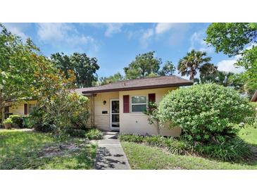 House exterior featuring a walkway, lush landscaping, and a charming entrance at 13 Villa Villar # 0, Deland, FL 32724
