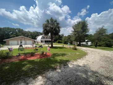 Home with detached garage and a charming front yard landscape at 3660 Grand Ave, Deland, FL 32720