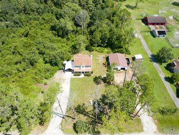 Aerial view of house, barn, and surrounding trees at 4205 Quail Ranch Rd, New Smyrna Beach, FL 32168