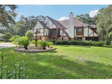 Two-story house with a fountain and manicured lawn at 1582 Covered Bridge Dr, Deland, FL 32724