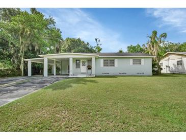 Charming light green house with carport and landscaped lawn at 1402 Talton Ave, Deland, FL 32720