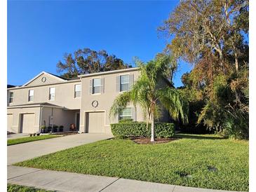 Two story townhome with attached garage, landscaping, and palm tree at 1630 Primo Ct, Daytona Beach, FL 32117