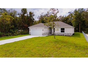 Newly built single-story home with stone accents and a two-car garage at 2202 Spruce St, Deland, FL 32724