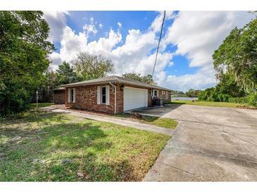Brick house exterior showcasing a garage and walkway, offering curb appeal at 660 Saxon Blvd, Deltona, FL 32725