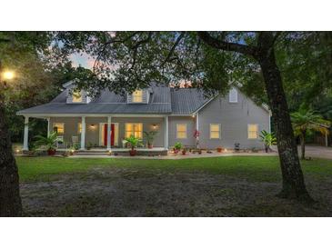 Two-story house with a porch and well-manicured lawn at 5711 John Anderson Hwy, Flagler Beach, FL 32136