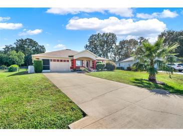 One-story home with a red accented facade and spacious driveway at 6008 Sw 103Rd Loop, Ocala, FL 34476