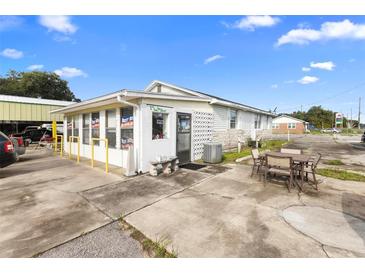 Exterior view of commercial building with outdoor seating at 2490 N Woodland Blvd, Deland, FL 32720