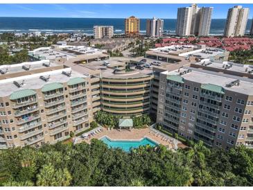 Aerial view of an apartment building with a pool and ocean view at 4 Oceans West Blvd # 108B, Daytona Beach, FL 32118