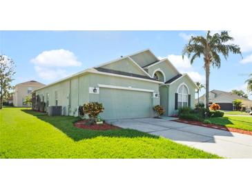 Two-story house with a green exterior, two-car garage, and well-manicured lawn at 101 Marathon Ln, Sanford, FL 32771