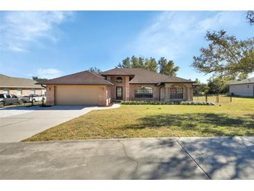 Brick house with a two-car garage and a well-maintained lawn at 1185 N Old Mill Dr, Deltona, FL 32725