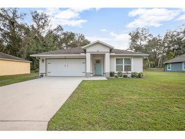 Newly constructed home with a white garage door and a nicely landscaped lawn at 1554 19Th St, Orange City, FL 32763